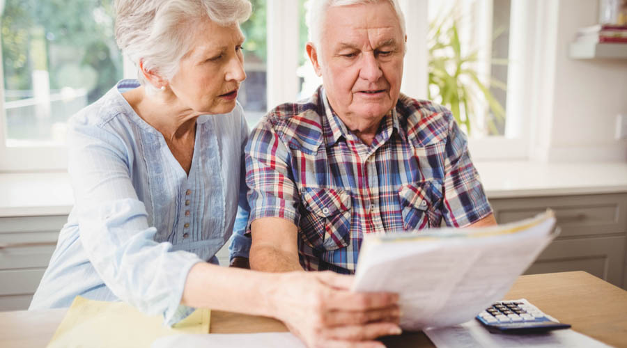Pareja de pensionados revisando documentos